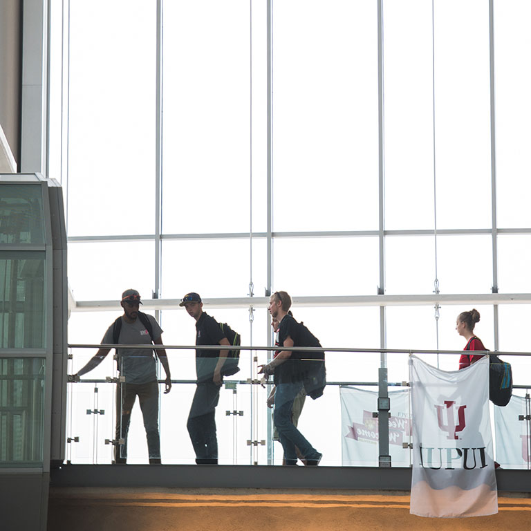 Students heading into the tunnel on the second floor of the campus center.